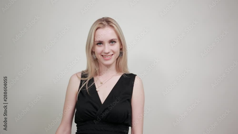 blonde girl in a black dress over isolated white background shows emotions blonde girl in a black dress over isolated white background shows emotions