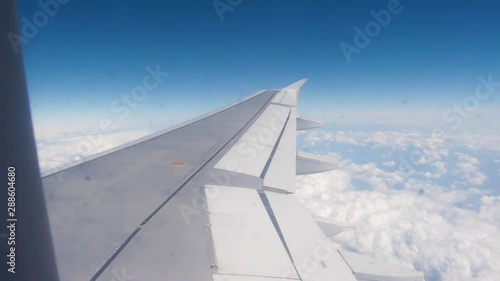 A vast beautiful view of  clear open skies as an airplane wing soars at cruising speeds at 35,000 feet. photo