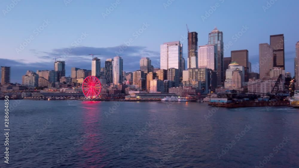 Panning view of downtown Seattle from water aboard Washington State Ferry arriving at Colman Dock from Bainbridge Island - Space Needle, Pier 57, and Great Ferris wheel seen during summer sunset 2019 Panning view of downtown Seattle from water aboard Washington State Ferry arriving at Colman Dock from Bainbridge Island - Space Needle, Pier 57, and Great Ferris wheel seen during summer sunset 2019