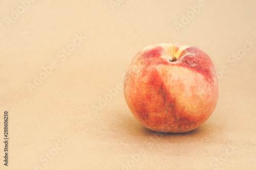 Bright fresh peach on a yellow beige background. Sweet juicy peach. Close. Space