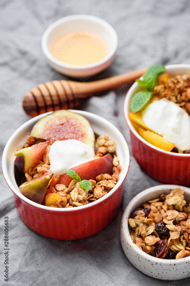 Crunchy oat granola with fruits and greek yogurt cream in bowl. Closeup view. Healthy breakfast food ingredients Crunchy oat granola with fruits and greek yogurt cream in bowl. Closeup view. Healthy breakfast food ingredients