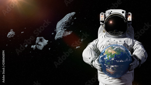 Fototapeta Naklejka Na Ścianę i Meble -  astronaut protecting planet Earth from asteroids, featuring Asia, Oceania and Australia