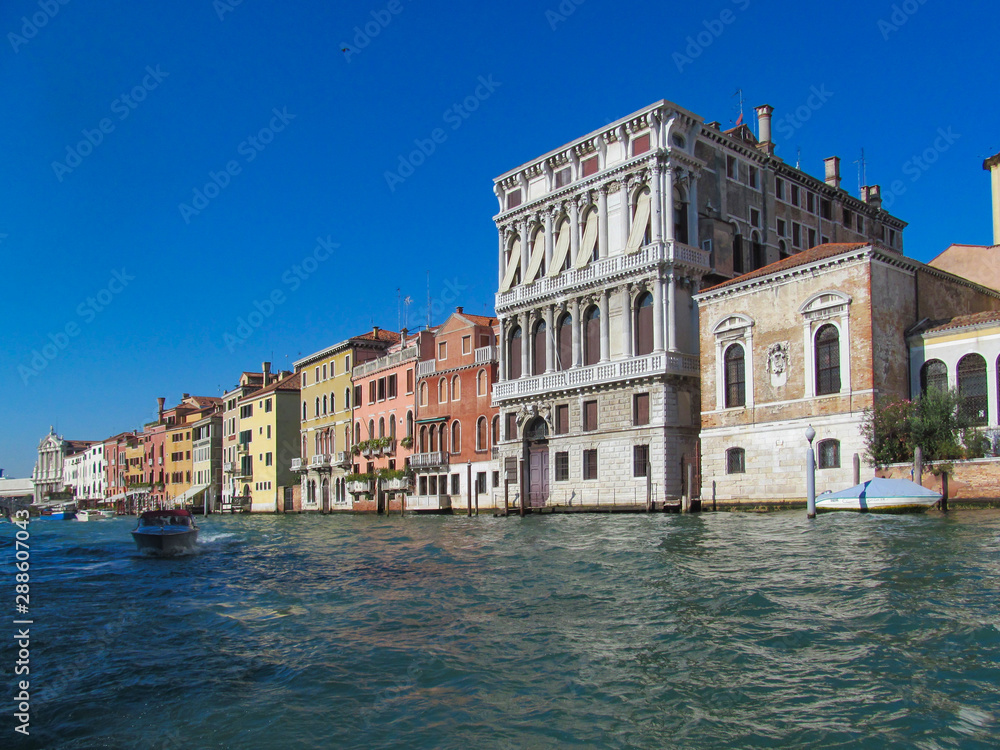 Grand Canal in Venice (Italy). Scenic view on famous Venetian landmarks - water surface and seafront with buildings and architecture attractions. 