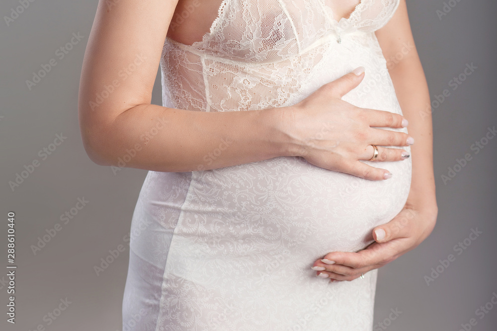 Close-up image of pregnant woman touching her belly with hands. Copy space Close-up image of pregnant woman touching her belly with hands. Copy space