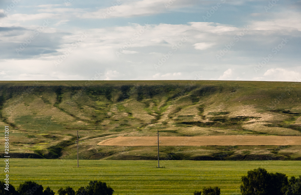 Fototapeta premium Eroded hill structure, agricultural field in steppe at Khakassia, Siberia, Russia.