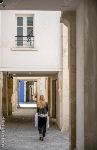 The girl with the package goes through the courtyards in Paris © vit