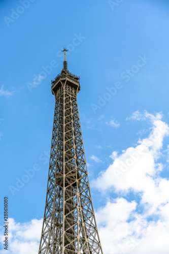 Truss top part of Eiffel Tower on the background of the cloudy sky