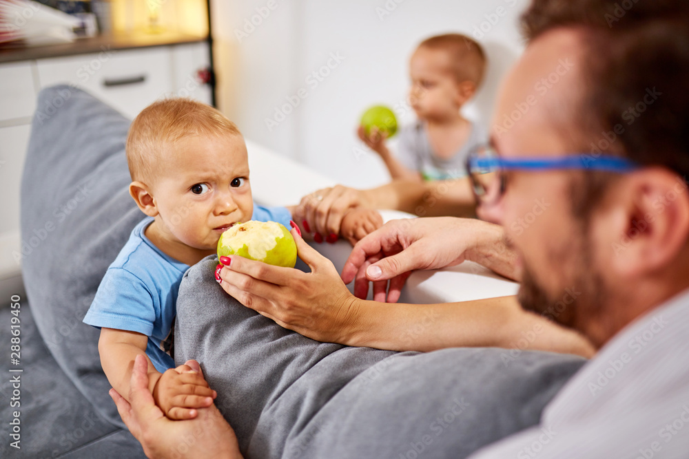 Parents feeding their baby with healthy green apple. Parents feeding their baby with healthy green apple.