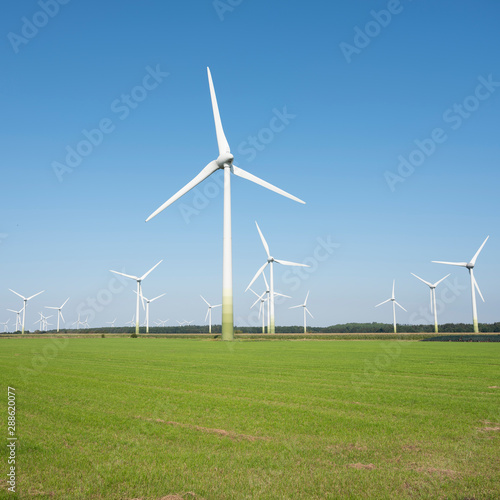 wind turbines in rural landscape of ostfriesland in the north of germany and blue sky