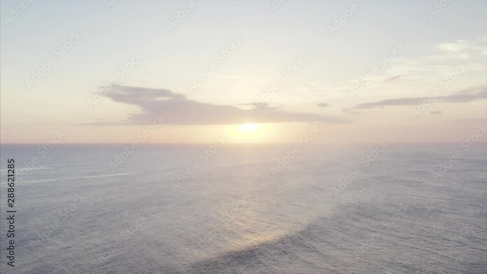 Aerial static view of bright sun going down in the ocean. Twilight. Calm waves of wonderful ocean. Bali, Indonesia Aerial static view of bright sun going down in the ocean. Twilight. Calm waves of wonderful ocean. Bali, Indonesia