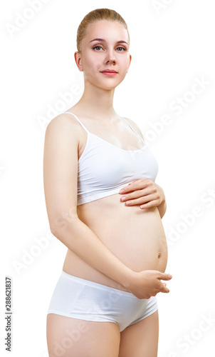 Pregnant woman with belly in the early stages of pregnancy in white underwear.