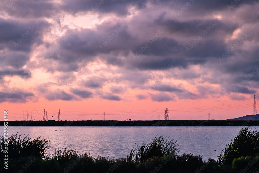 Sunset clouds and pink sky over the salt ponds of South San Francisco Bay Area; Sunnyvale, California