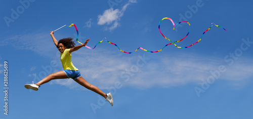 Cute young girl jump with ribbon in heart shape