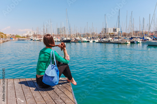 Tourist woman in the port of Barcelona, Catalonia, Spain. Scenic seascape of marina and sailboats yachts. Public promenade and famous tourist destination near La Ramblaa street © oleg_p_100