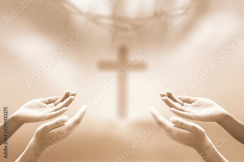 Fotografija Worship concept: Two human hands praying over blurred crown of thorns and the cr
