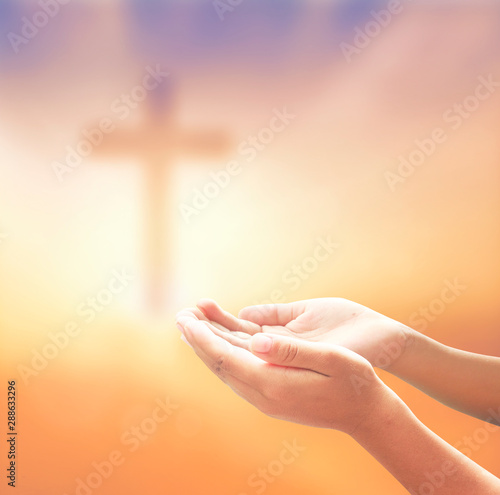 hand with on blurred cross background