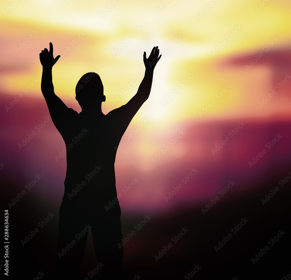 Worship God concept: Silhouette of man with arms raised