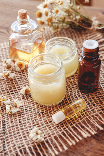 Hand cream and lip balm in a glass jar. Natural organic cosmetics with honey, wax and oils.