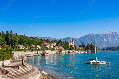 Panorama landscape on beatiful Lake Como in Tremezzina, Lombardy, Italy. Scenic small town with traditional houses and clear blue water. Summer tourist vacation on rich resort with nice harbour photo
