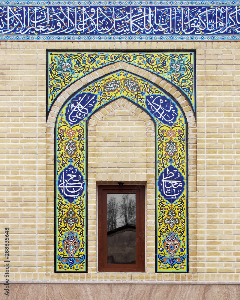 Mosque wall with Arabic calligraphy on decorative mosaic tiles 
