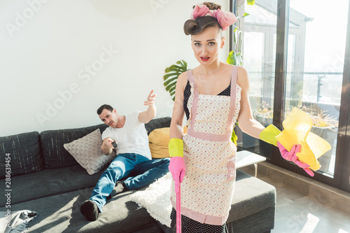 Bild auf Leinwand Wife is mad at her lazy husband who is not helping with chores