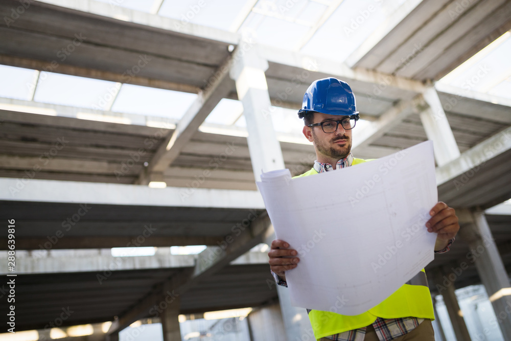 Construction engineer in hardhat with project in hands Construction engineer in hardhat with project in hands