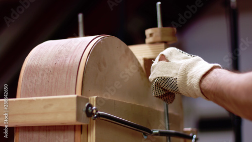 Luthier Makes an acoustic guitar body in his shop