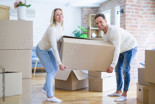 Young beautiful couple moving cardboard boxes at new home © Krakenimages.com