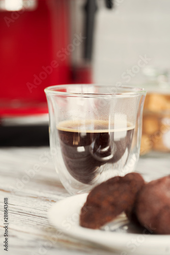 Glass cup of coffee at kitchen counter close up