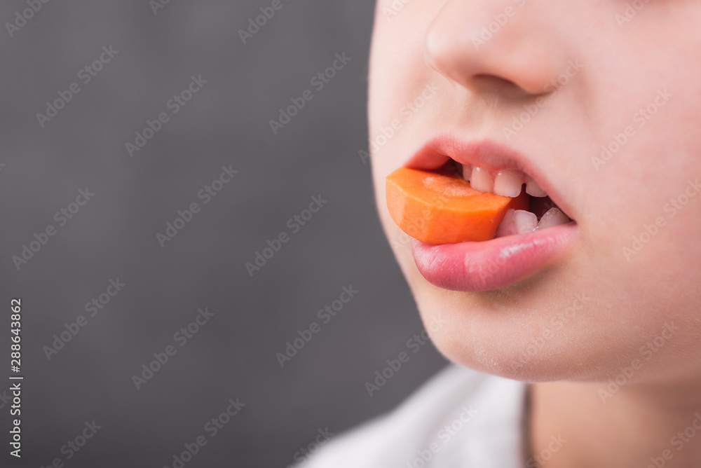 small boy eat fresh carrot