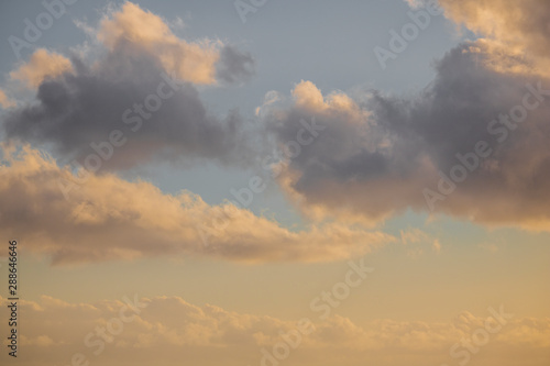 Close up of clouds on a pastel blue and golden sky.