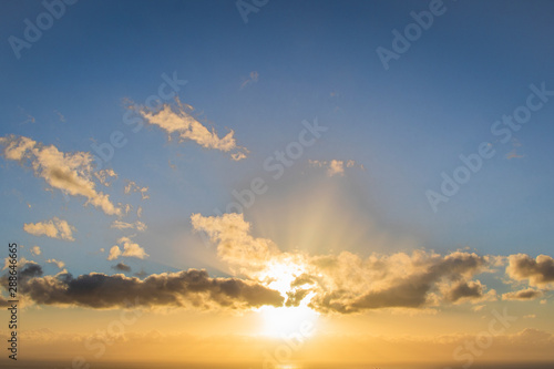 Fototapeta Naklejka Na Ścianę i Meble -  Sun setting over a golden blue sunset over the ocean.