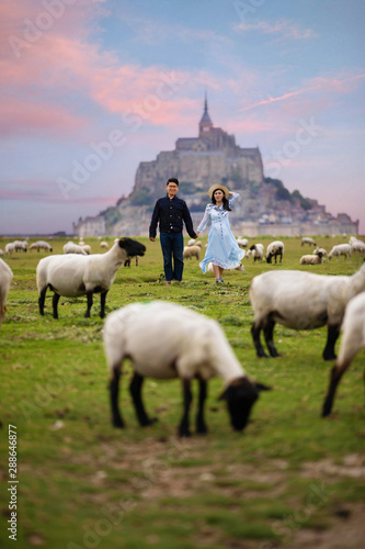 Young couple is travel at Mont Saint Michel during summer time in Normandy,France as for pre-wedding photograph.
