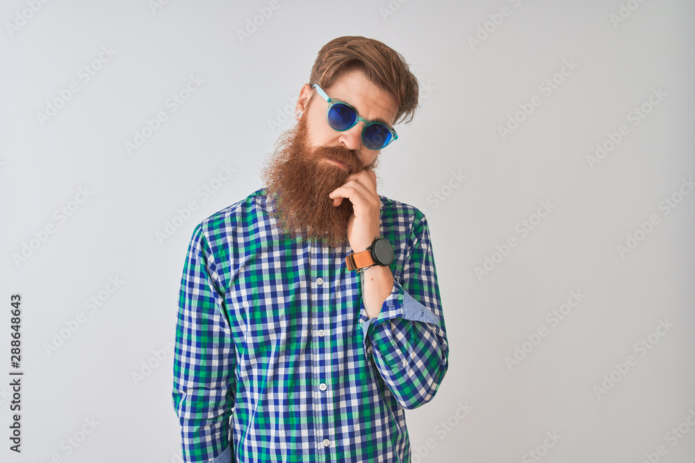 Young redhead irish man wearing casual shirt and sunglasses over isolated white background thinking looking tired and bored with depression problems with crossed arms. Young redhead irish man wearing casual shirt and sunglasses over isolated white background thinking looking tired and bored with depression problems with crossed arms.