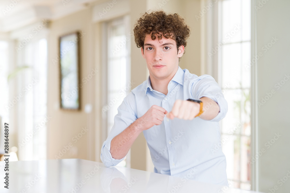 Young business man with curly read head Punching fist to fight, aggressive and angry attack, threat and violence