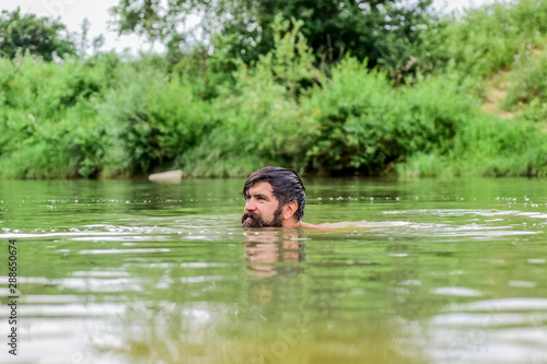 Freshness of wild nature. Summer vacation. Deep dangerous water. Relaxation and rest. Swimming sport. Swimming skills. Refreshing feeling. Man enjoy swimming in river or lake. Submerge into water