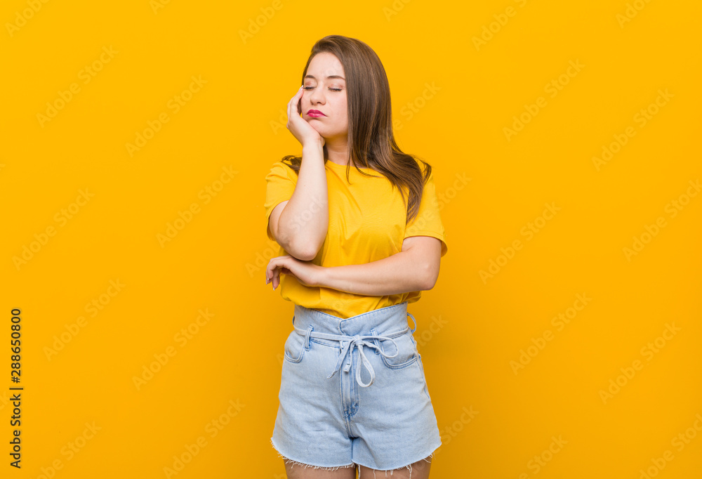 Young woman teenager wearing a yellow shirt who is bored, fatigued and need a relax day. Young woman teenager wearing a yellow shirt who is bored, fatigued and need a relax day.