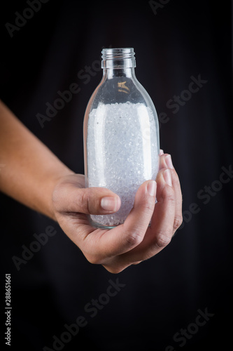 Hand holding a jar of white plastic