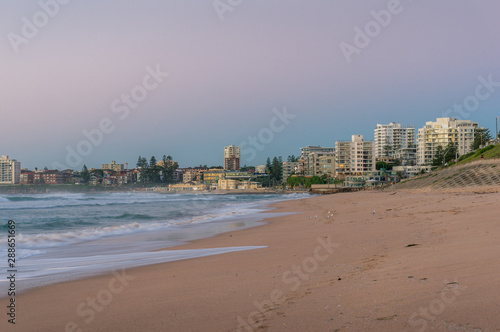 Australian beach on sunrise with waterfront property on the background © Olga K