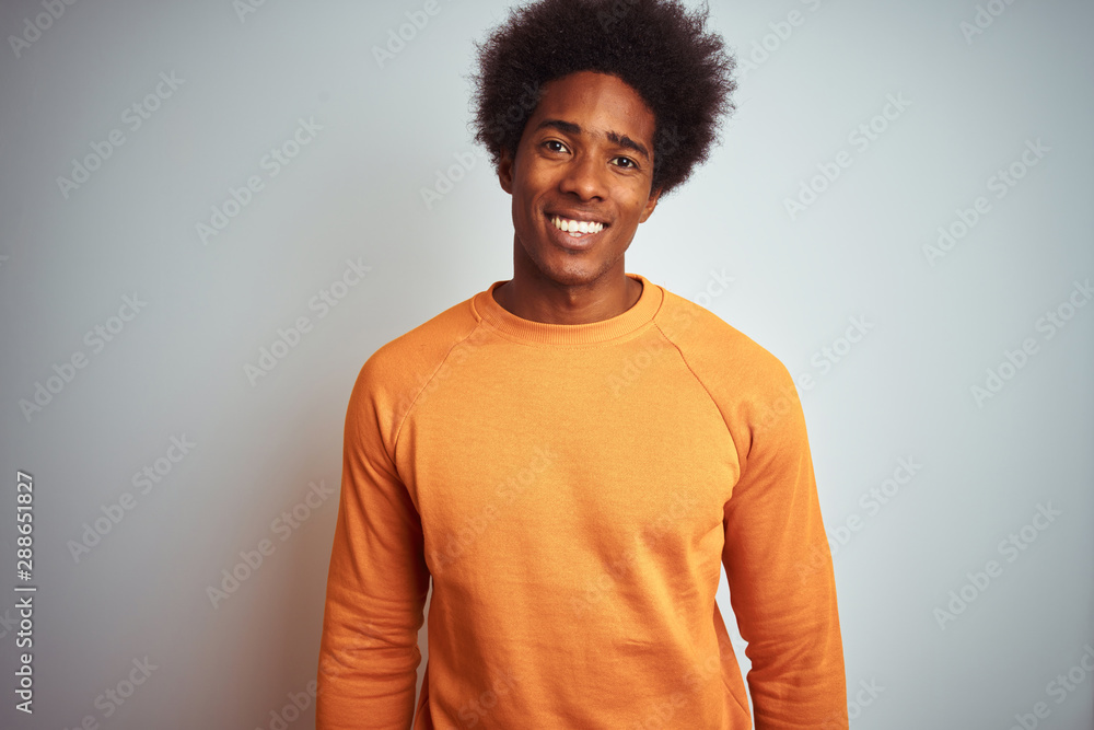 Young american man with afro hair wearing orange sweater over isolated white background with a happy and cool smile on face. Lucky person. Young american man with afro hair wearing orange sweater over isolated white background with a happy and cool smile on face. Lucky person.