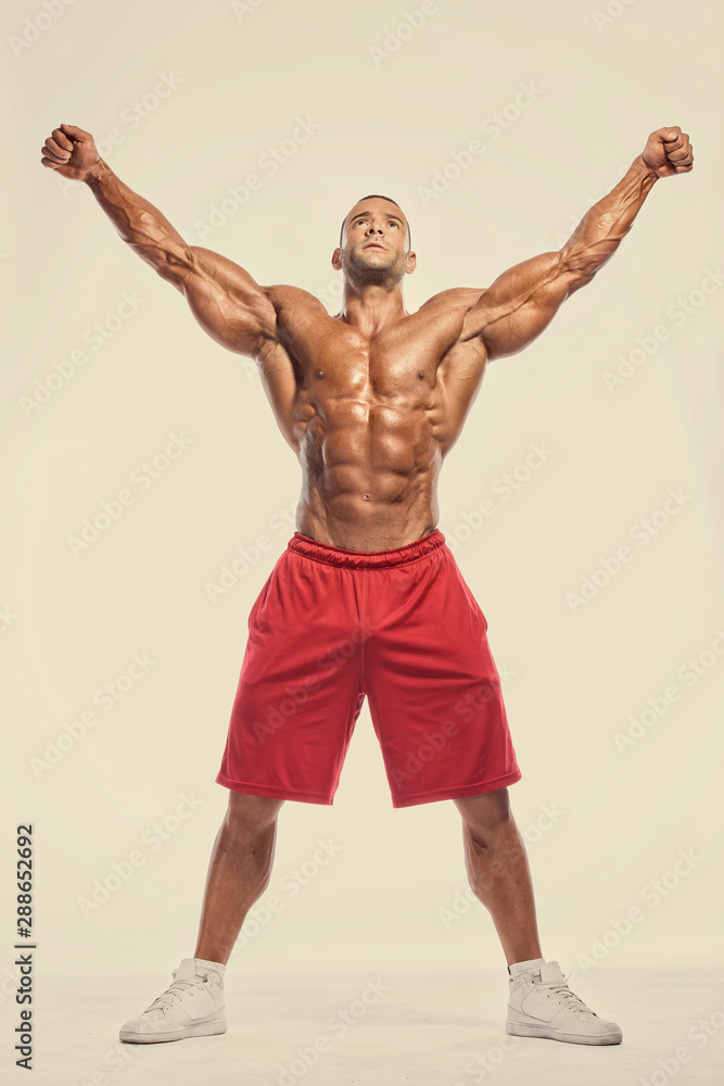Obraz premium Handsome, Strong BodyBuilder Flexing Muscles