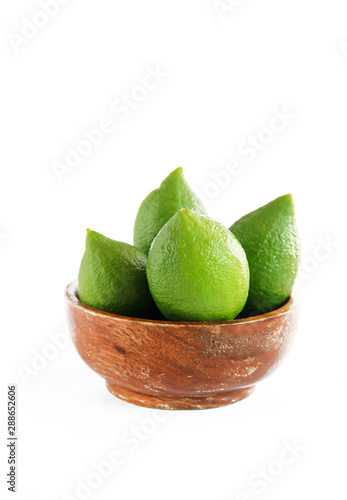 fruits of green natural lime lemon in a wooden brown a plate