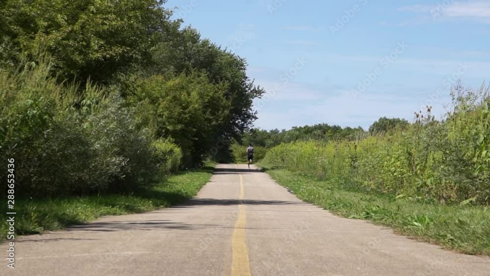 young runner training on forest preserve trail young runner training on forest preserve trail