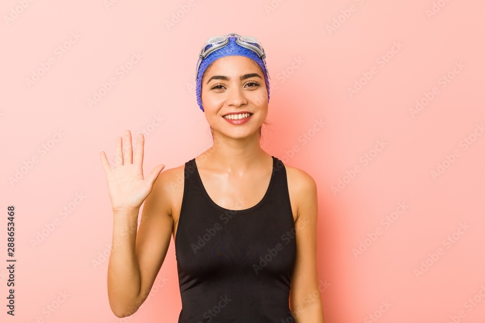 Young arab swimmer woman isolated smiling cheerful showing number five with fingers. Young arab swimmer woman isolated smiling cheerful showing number five with fingers.