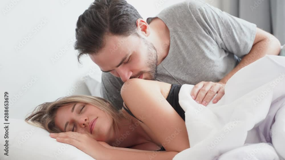 Young couple kissing cheek in the bed wake up in the morning. loving couple in bedroom Young couple kissing cheek in the bed wake up in the morning. loving couple in bedroom