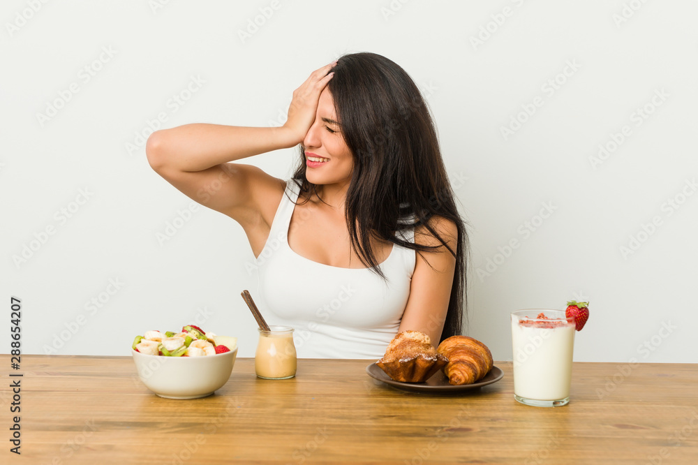 Young curvy woman taking a breakfast forgetting something, slapping forehead with palm and closing eyes. Young curvy woman taking a breakfast forgetting something, slapping forehead with palm and closing eyes.