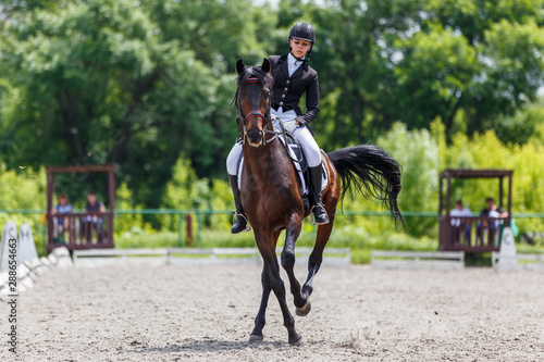 Young woman riding horse on dressage advanced test © skumer
