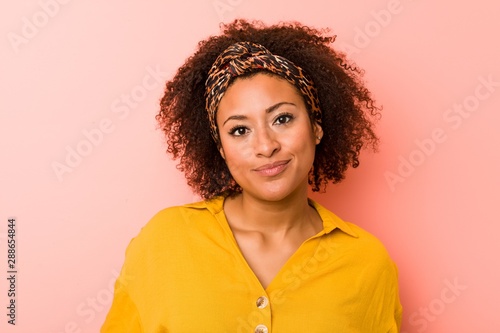 Young african american woman against a pink background