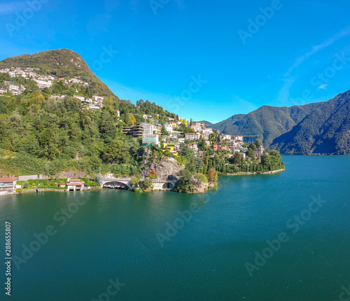 Panorama aerial view of the lake Lugano, mountains and city Lugano, Ticino canton, Switzerland. Scenic beautiful Swiss town with luxury villas. Famous tourist destination in South Europe