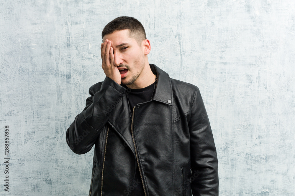 Young rocker man having fun covering half of face with palm. Young rocker man having fun covering half of face with palm.